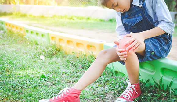 child holding knee in pain