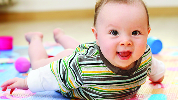 A newborn smiles during tummy time