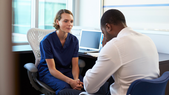A nurse converses with a patient struggling with mental health.