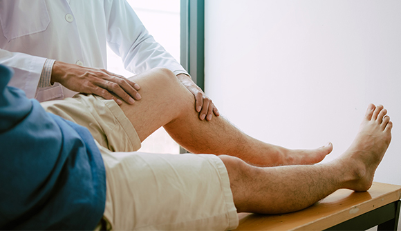 Man having PAD-pain in his leg examined by a doctor.