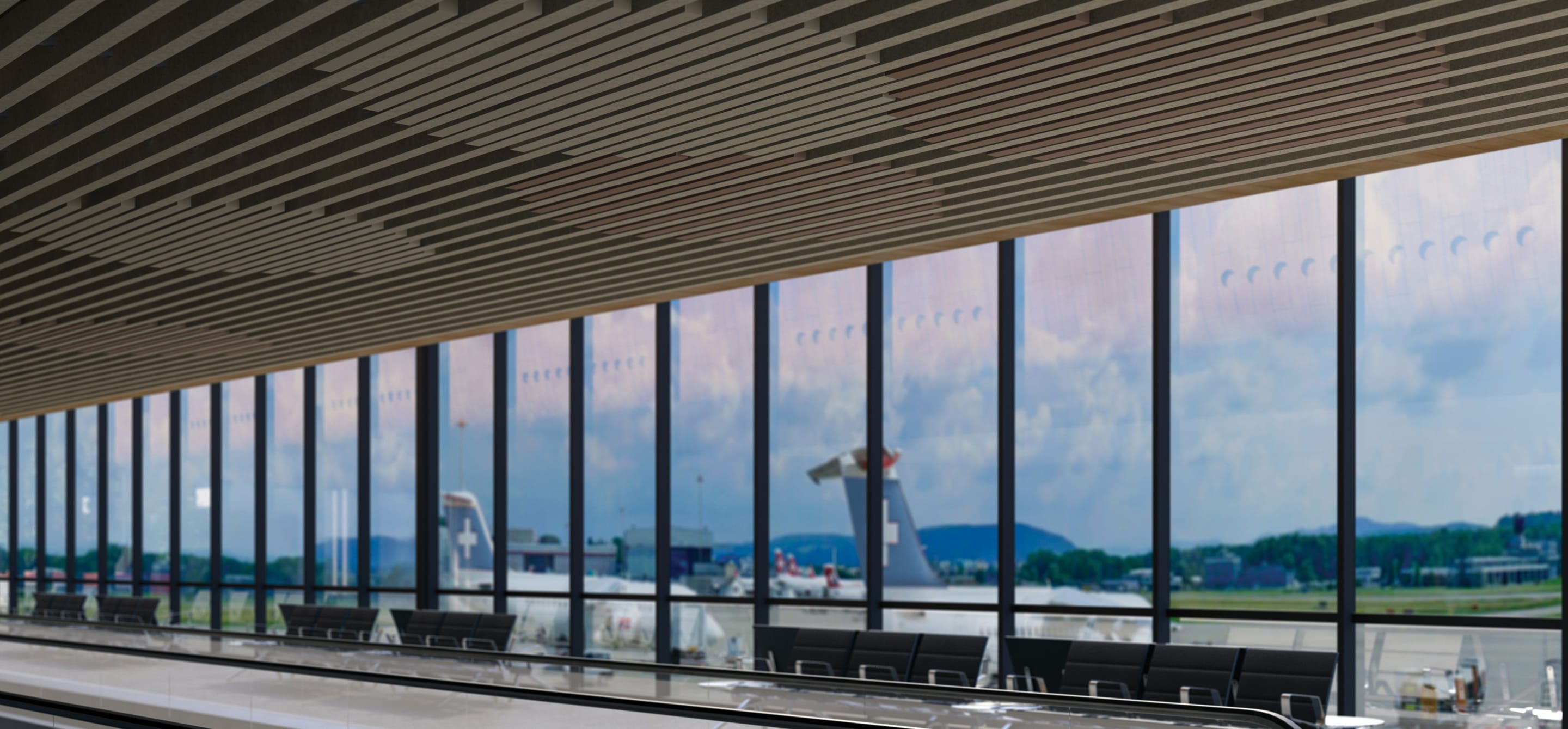 A modern, large-scale airport terminal featuring Zintra Box Baffles Span across the ceiling. The staggered linear acoustic baffles provide an architectural, rhythmic design while ensuring high-performance sound absorption in a high-traffic transit environment.