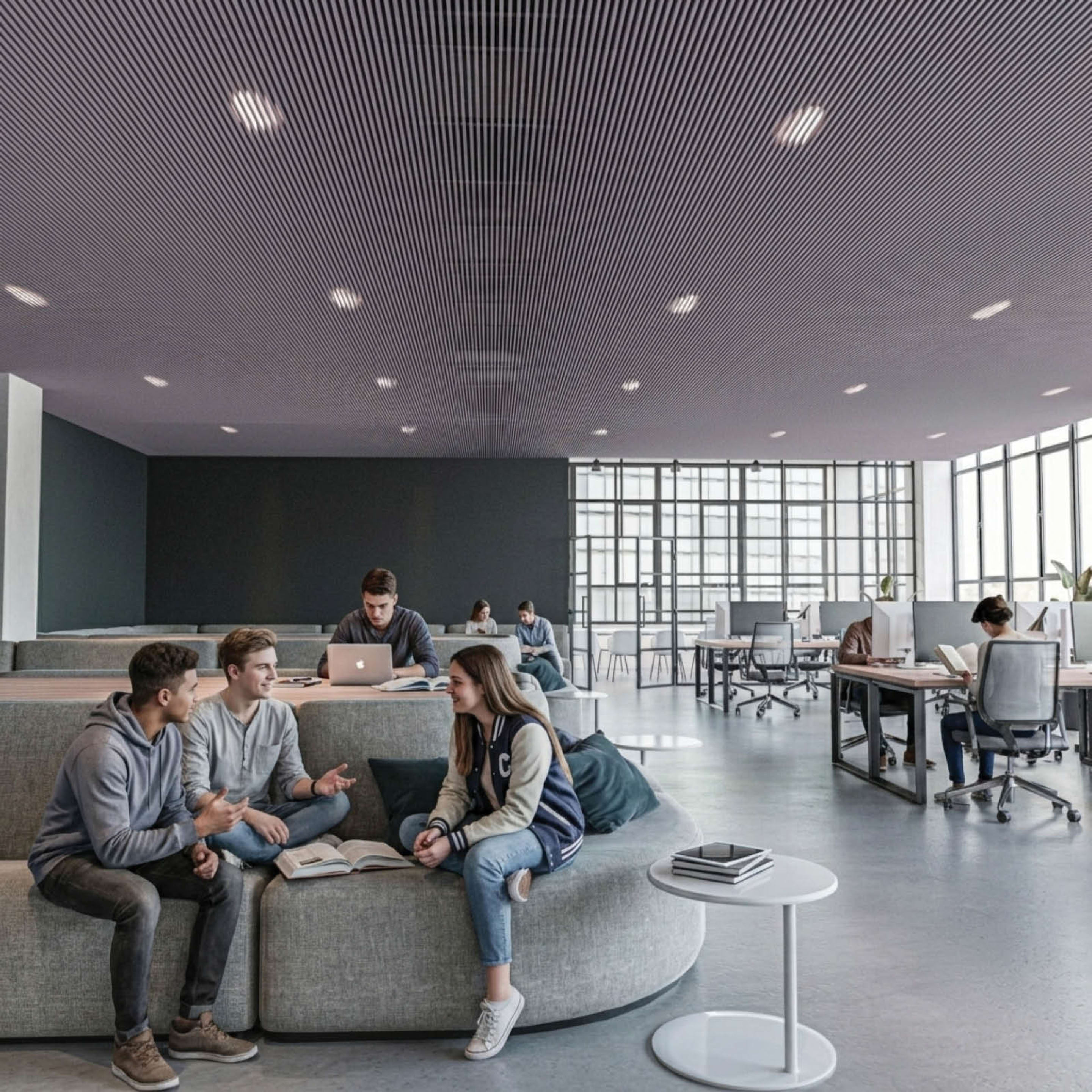 Students collaborating on modern lounge seating beneath a grey Zintra Baffle System HD Straight acoustic ceiling in an educational third space.
