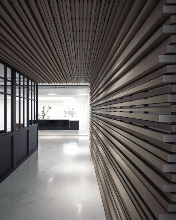 A modern hallway featuring Zintra Quadratic Sticks, seamlessly transitioning from the wall to the ceiling. The linear acoustic panels add texture and depth, enhancing both aesthetics and sound absorption in the sleek, contemporary office space.