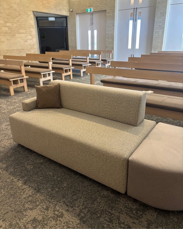 botton+gardiner Atomik modular lounge in Baresque's beige textured fabric,  providing comfortable, durable seating inside a service room with timber pews at Geelong Memorial Park & Crematorium.
