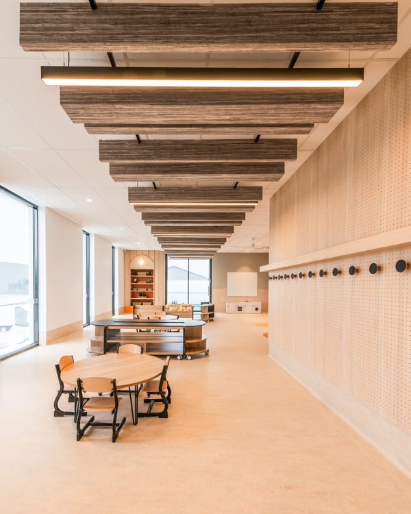 The interior of Westcare Early Learning Centre (ELC) featuring an open-plan space with wooden furniture and furnishings and the ceiling is accented with Zintra Box Baffles Random