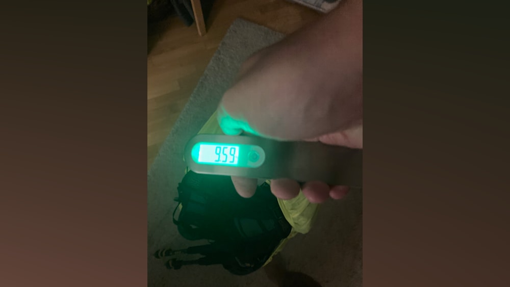 a person holding a digital scale with 949 on the screen.