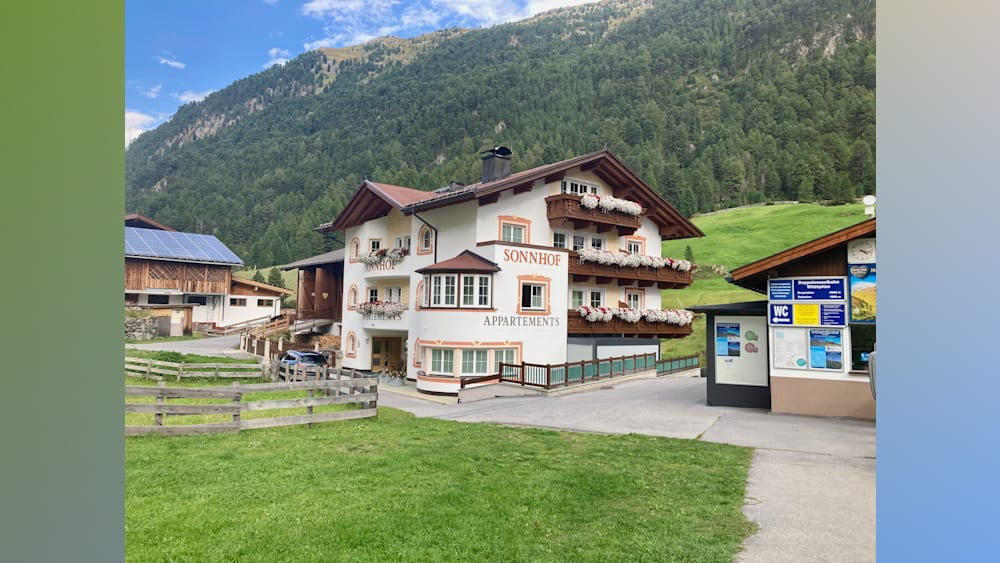 A building with apartments and a field behind it.