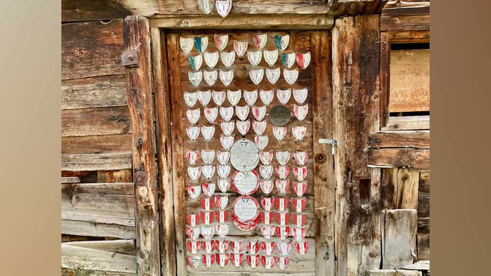 A wooden door has a plaque with numbers and hearts on it.