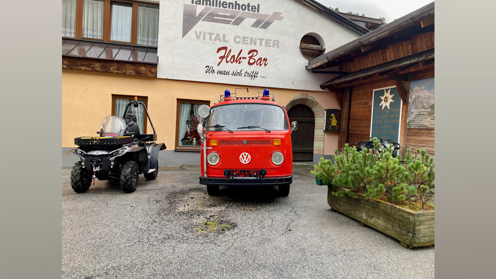 A VW van parked in front of a building with a sign that says Vital Center.