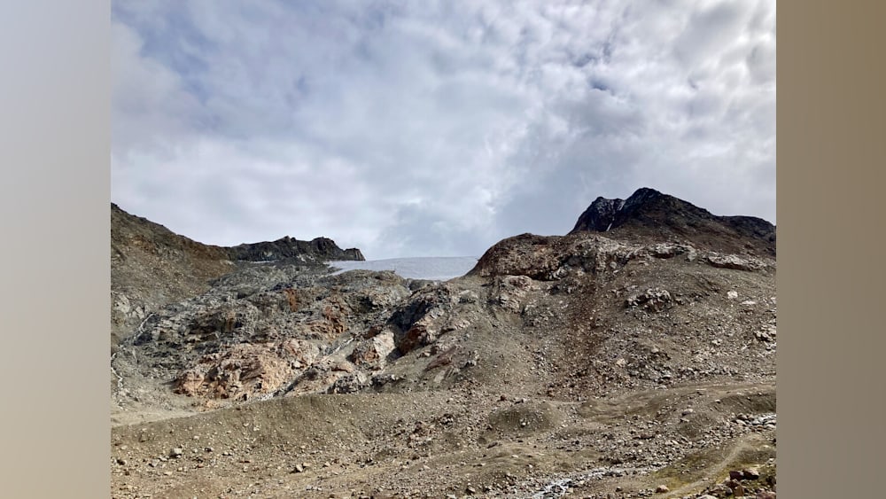 A large open area with a lot of rocks and a body of water in the distance.