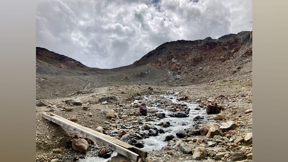 A stream of water runs down some rocks in a deserted area.
