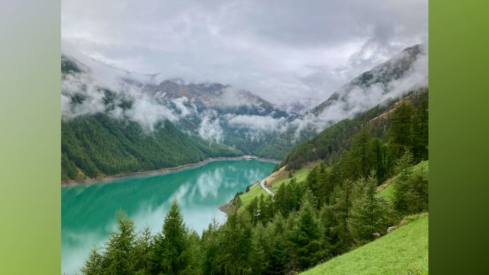A lake surrounded by trees and mountains is shown in the image.