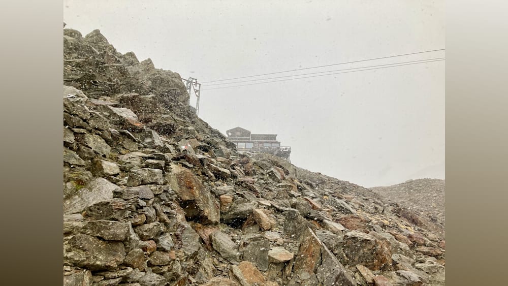 A house sits atop a pile of rocks in the rain.