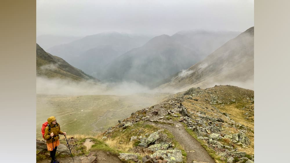 fog blankets the mountains and the path leading to the top.