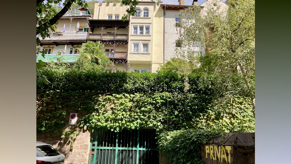 A large green and yellow sign that says Private on a building.