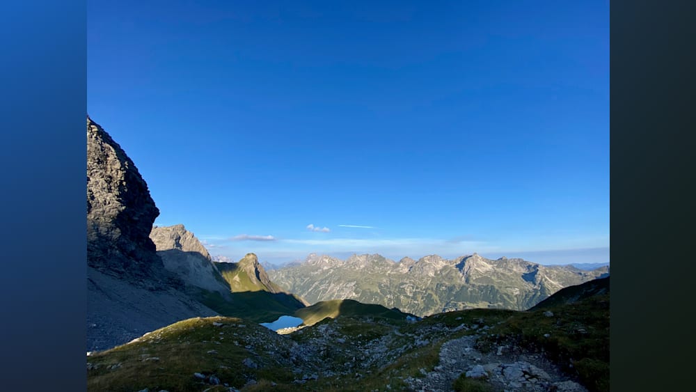 A mountain with a lake in the middle of it and the sky is blue with no clouds.