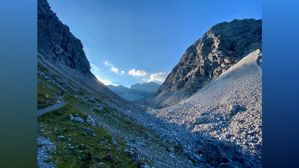 A valley with a mountain in the background is full of rocks.