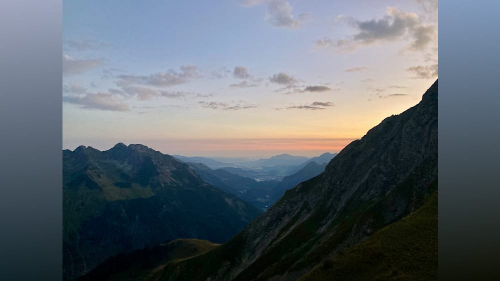 The mountains have a beautiful orange glow as the sun sets.