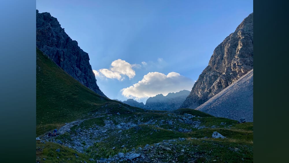 A mountain with a large cloud in the valley below.