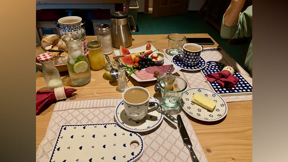 A table with food and drinks on it with a blue and white tablecloth.