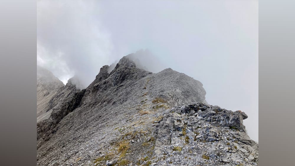 A foggy mountain peak covered in rocks.
