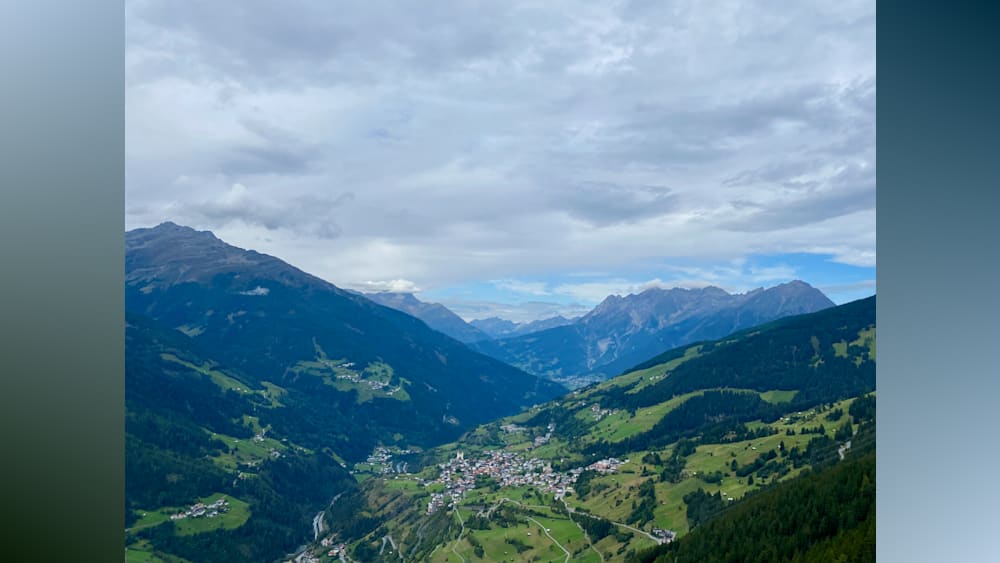 A valley with a mountain in the background with a town in the valley.