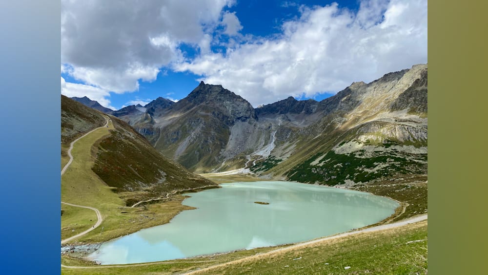 A large lake surrounded by mountains is shown with a small island in the middle.