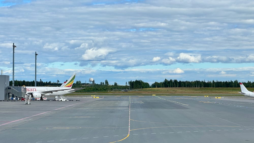 An empty runway with two planes sitting on it.