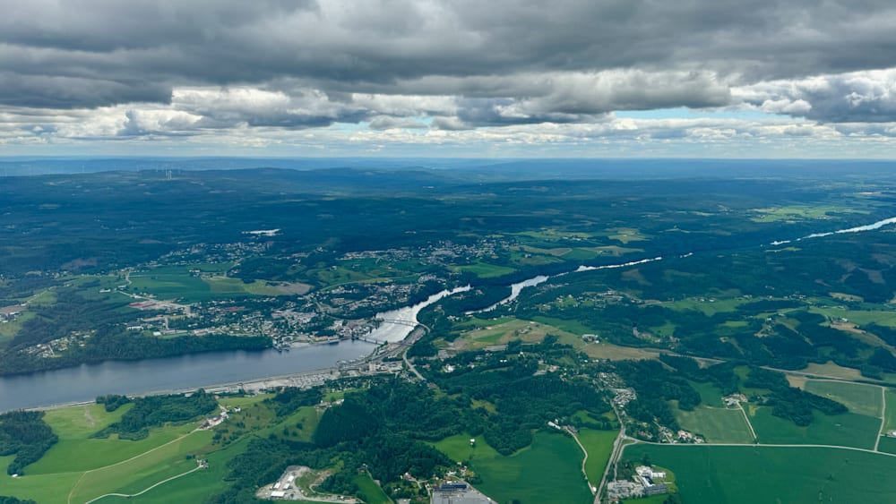 An aerial view of a town with a body of water in the foreground.