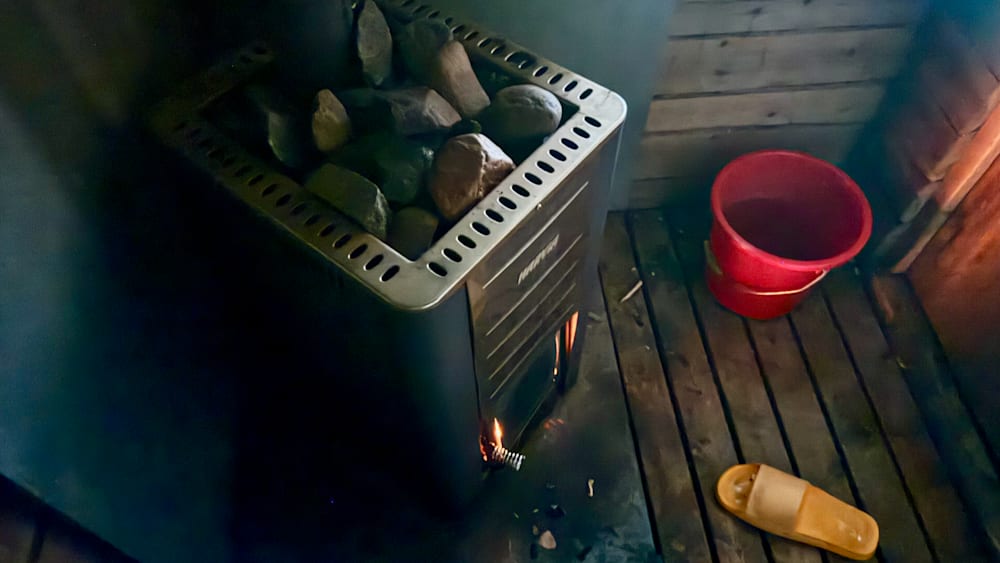A fire is burning in a heater with rocks inside of it.