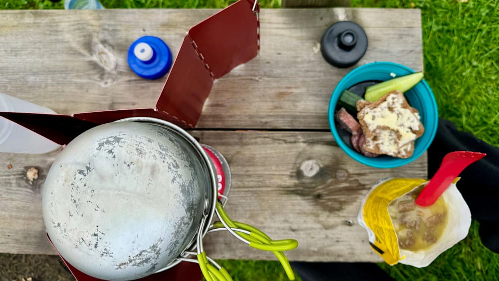 A picnic table with a pan and two bowls on it.