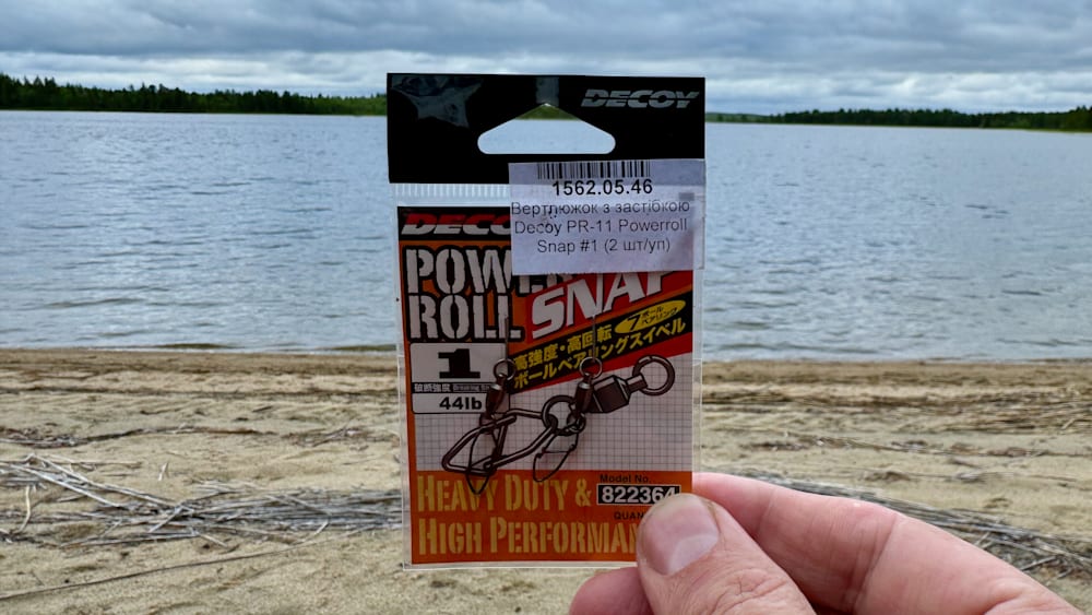 A hand holding a decoy power roll snap with the hook out.