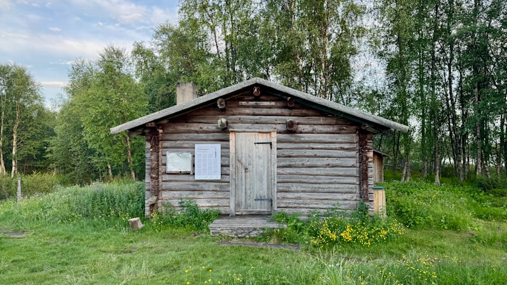 A log cabin with a sign on the front of it.