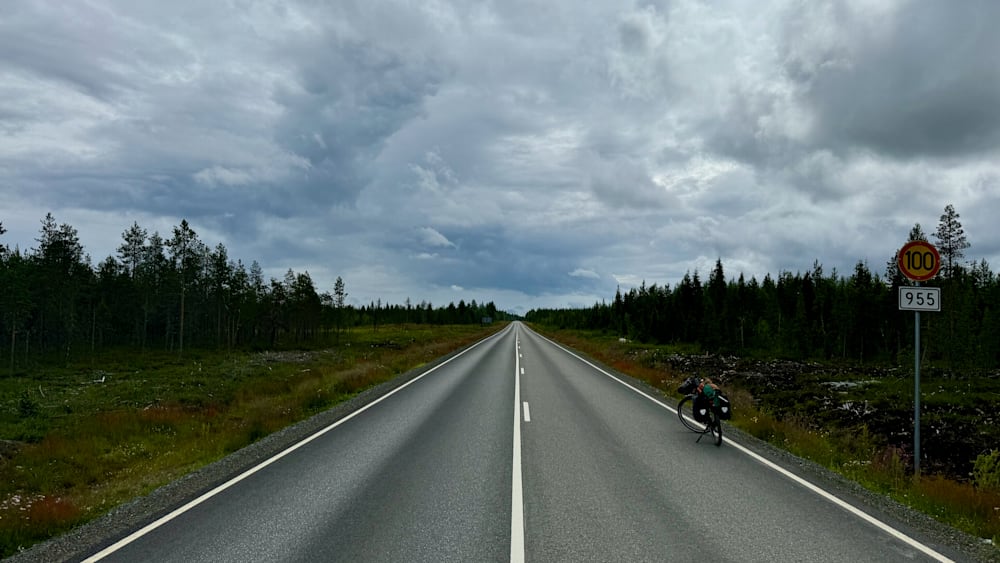 An empty road with a bike parked on the side.