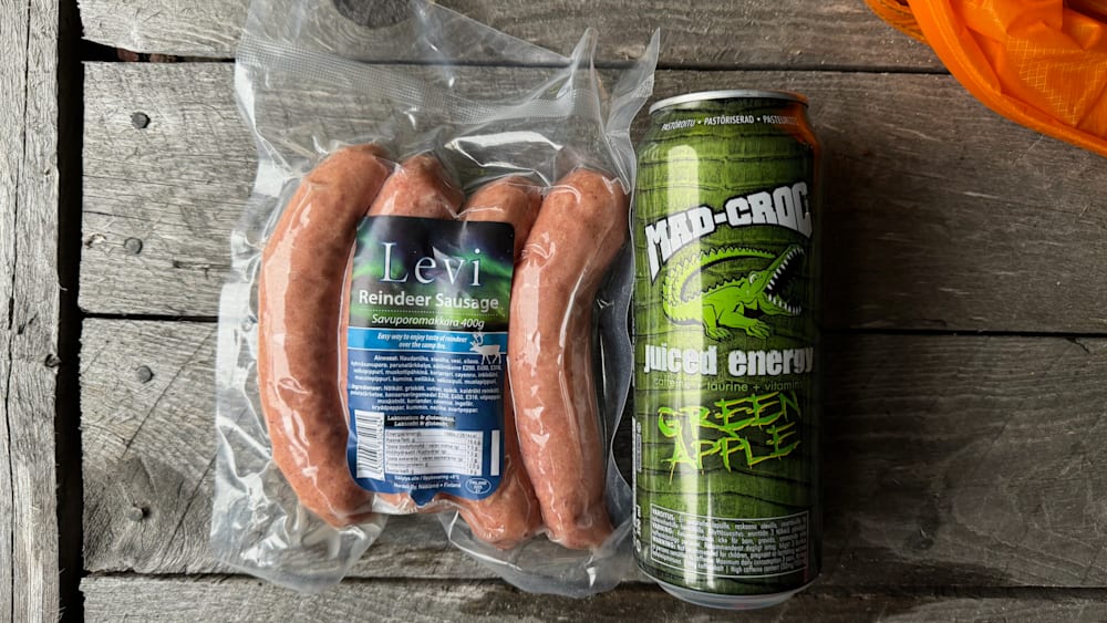 Three links of meat with a can of juice energy next to them.