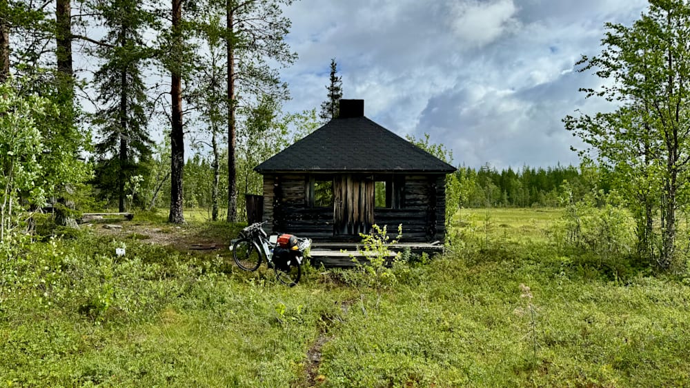 A log cabin with a bike parked outside.