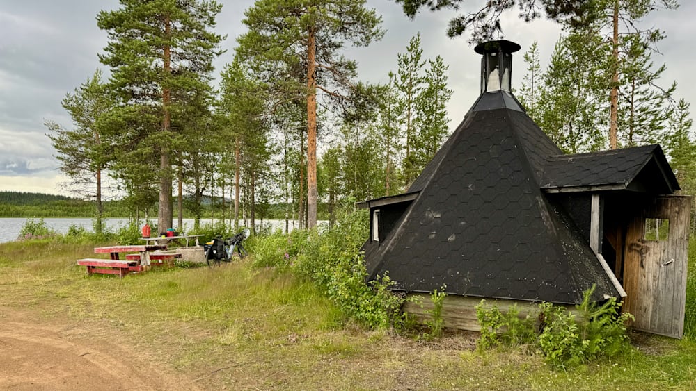 A small cabin with a grassy area next to a road.