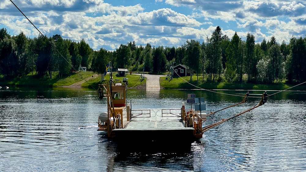 A boat on a body of water with a dock in the background.