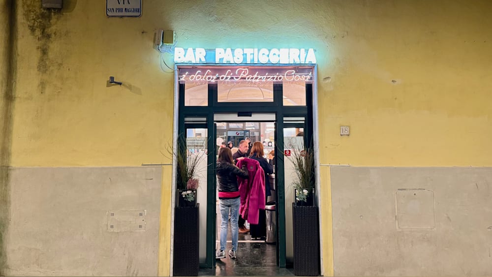 People are standing outside a bar called Pastigerieia.