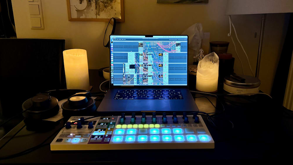 A laptop with music software open and a candle next to it.