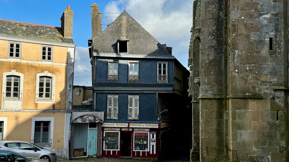 A large blue and white building with shutters on the windows.
