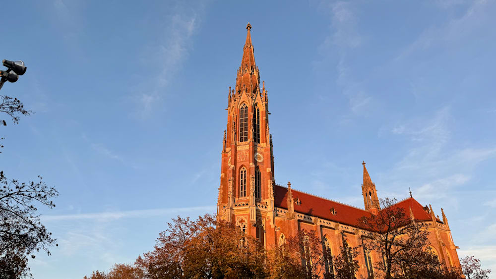 A large church with a tall spire and a clock tower.