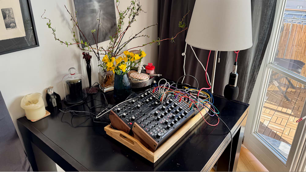 A sound board with many wires and a lamp with a vase of flowers next to it.