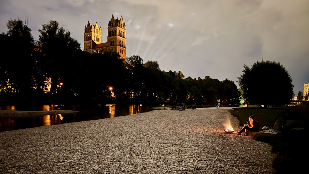 A fire is burning in a river of sand, with a cathedral in the background.