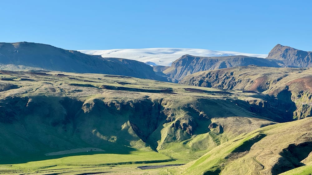 A mountain with a large slab of snow on top of it.