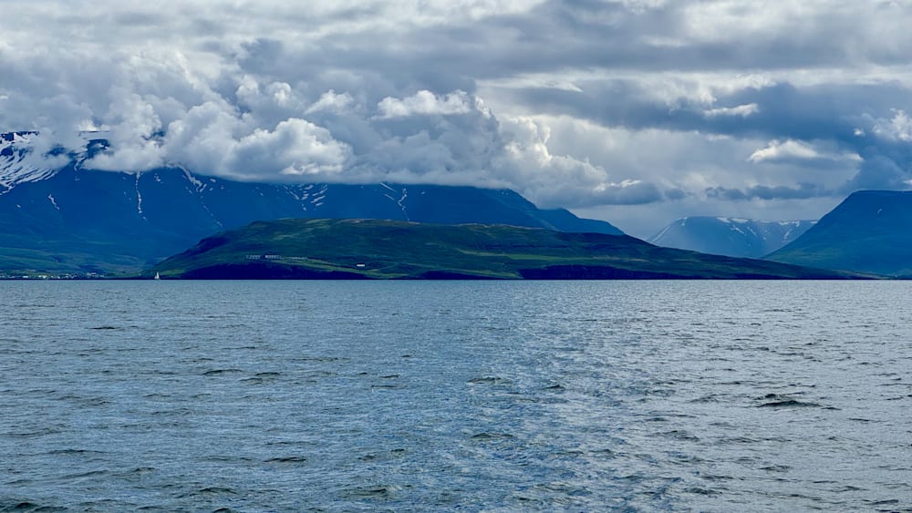 The ocean meets the clouds and the land rises up from the water.