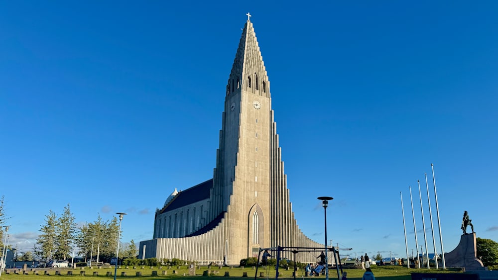 A large church with a steeple and clock is shown on a clear day.