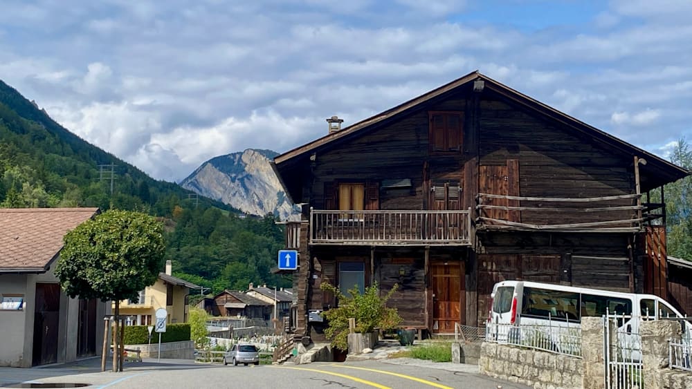 A road with a yellow line and a house on the side of it.