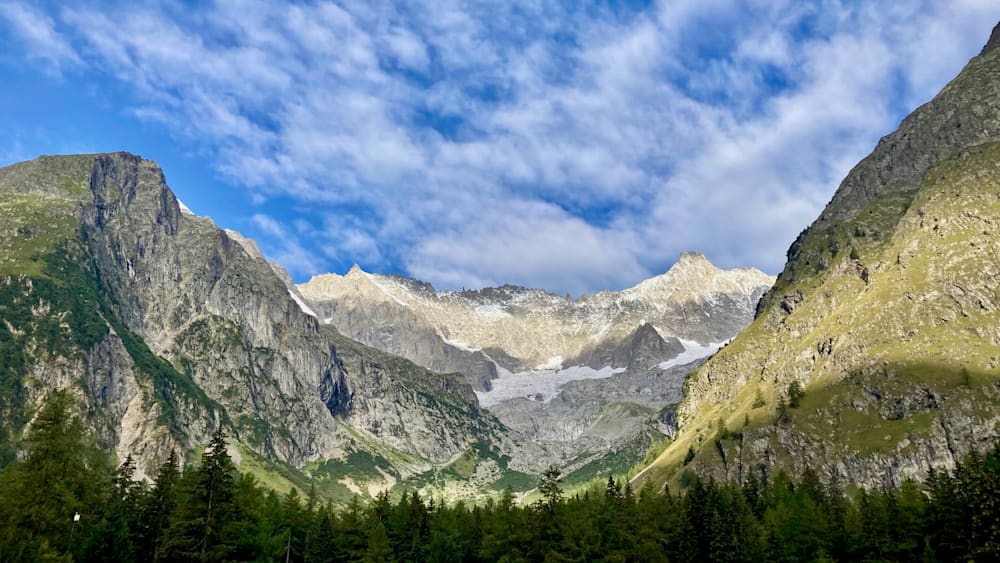 A mountain with snow on its peak and a blue sky in the background.