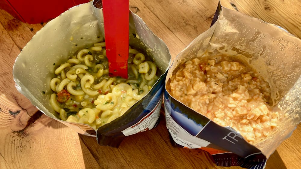 Two bags of food with one being macaroni and cheese and the other being rice.